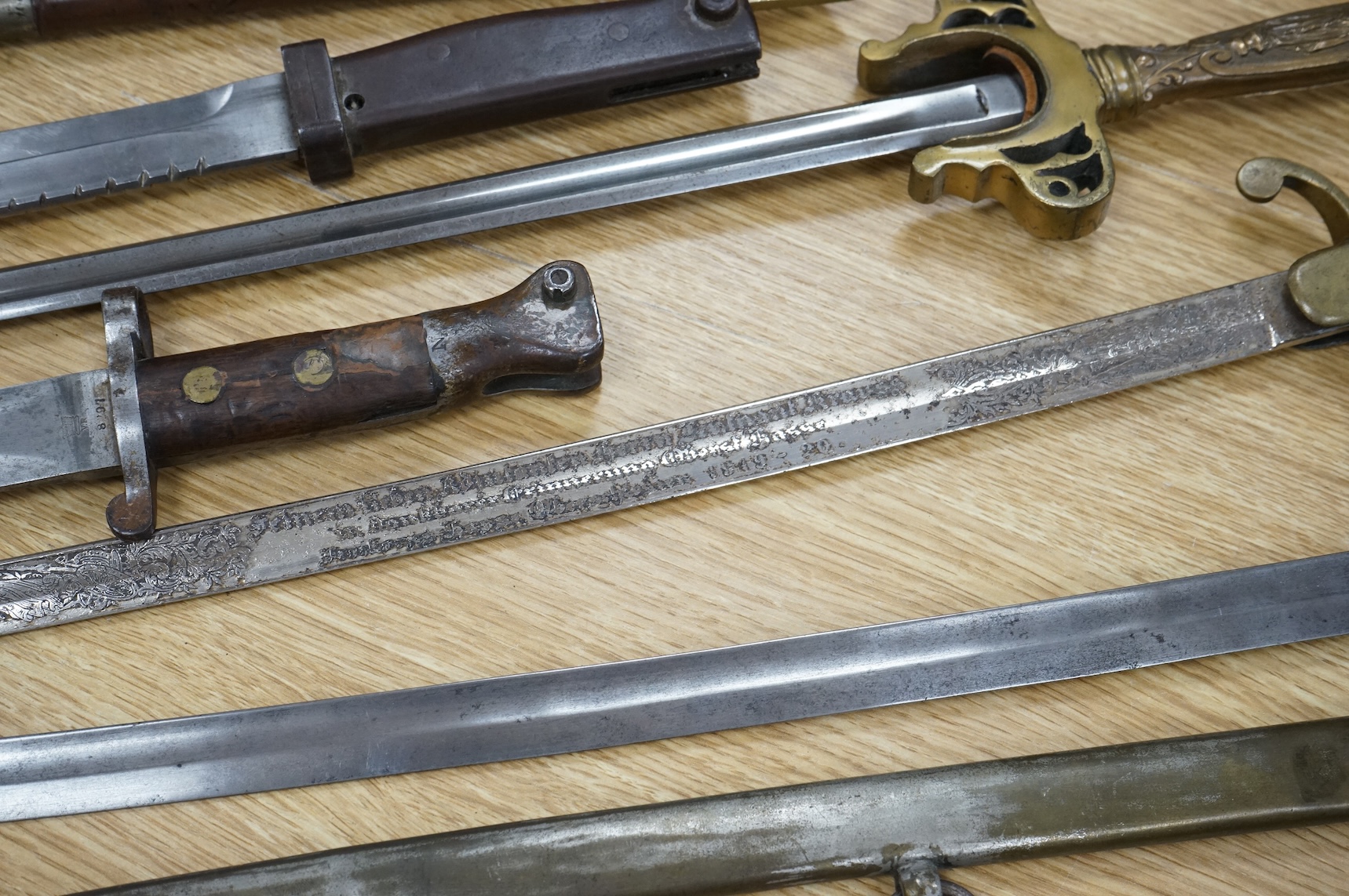 An Imperial German presentation infantry officer’s sword dated 1919/20, another similar with plain blade and brass stirrup hilt, another similar, plain in steel scabbard, a Wilkinson masonic sword probably circa 1950, a